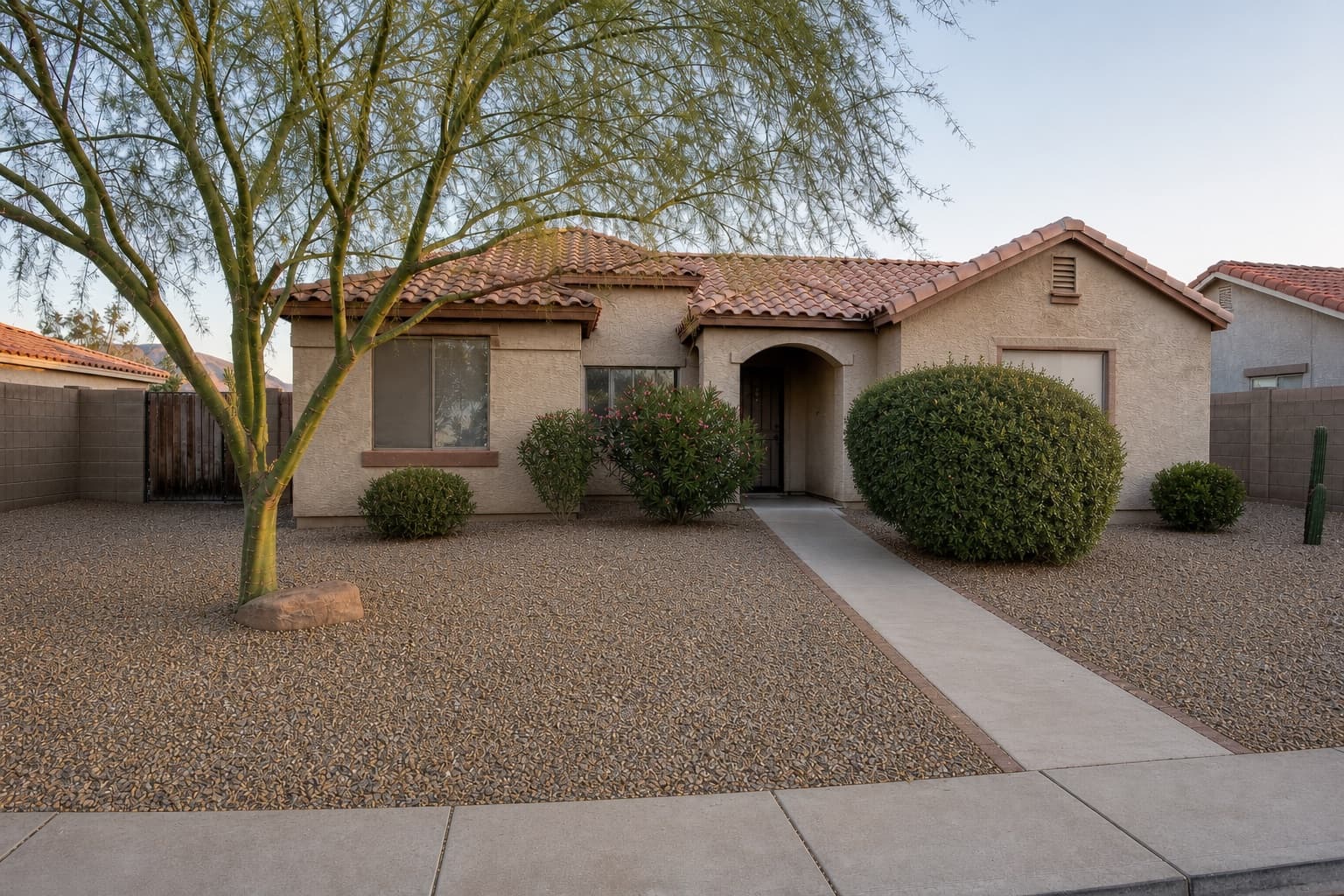 Front-yard reset: weeds and dead fronds → clean raked gravel after